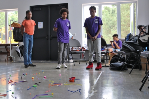 Three young people play with remote controlled cars during a Skills Ontario summer camp event.